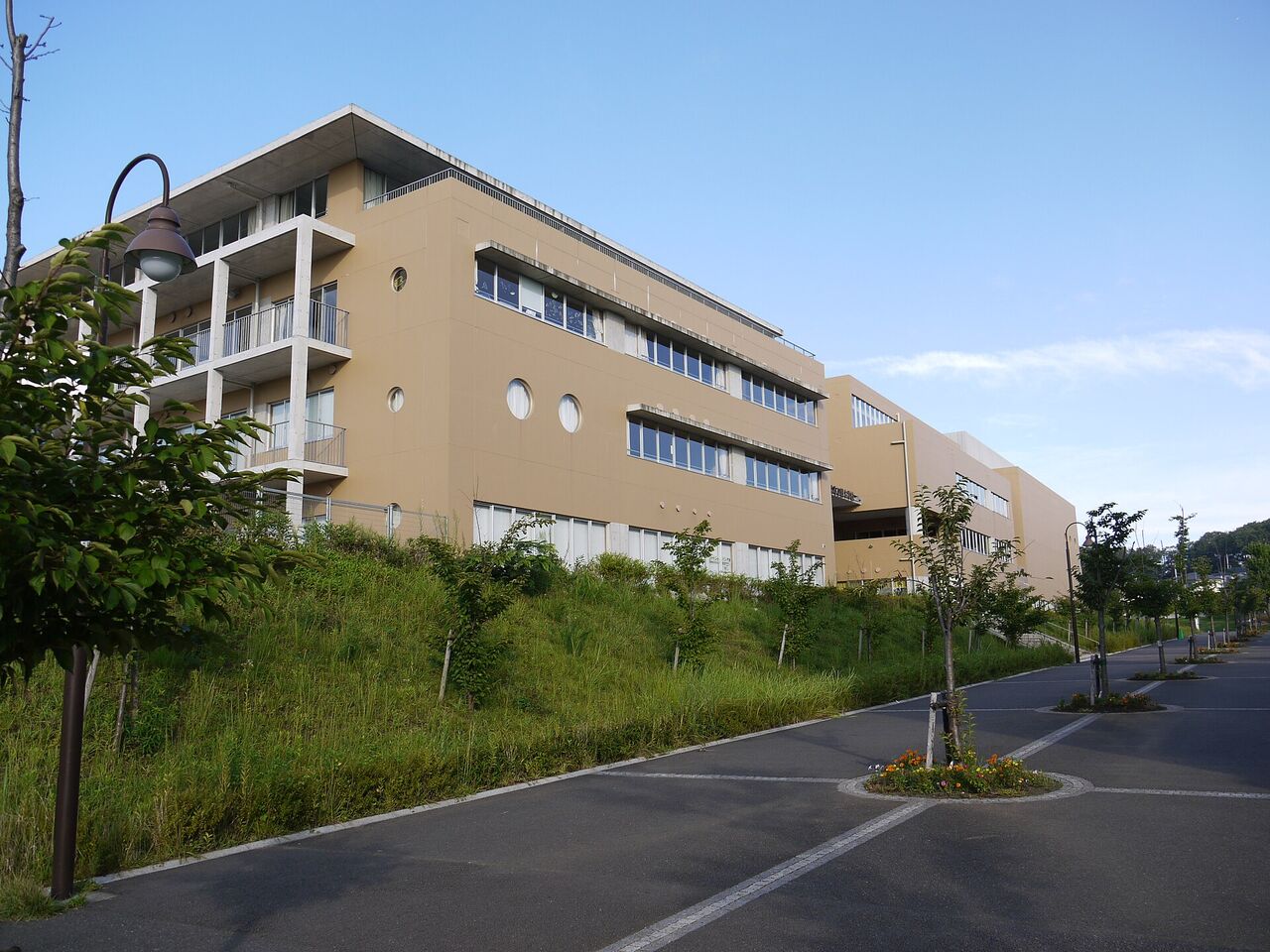 はるひ野小学校・はるひ野中学校の校舎。ベージュ色の外壁の建物が坂の上に建っている
