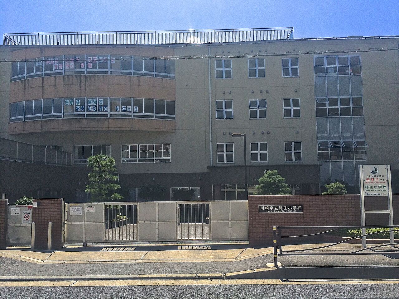 柿生小学校の正門。門の横に「ここは震災時の避難所です」と書かれた看板が立っている