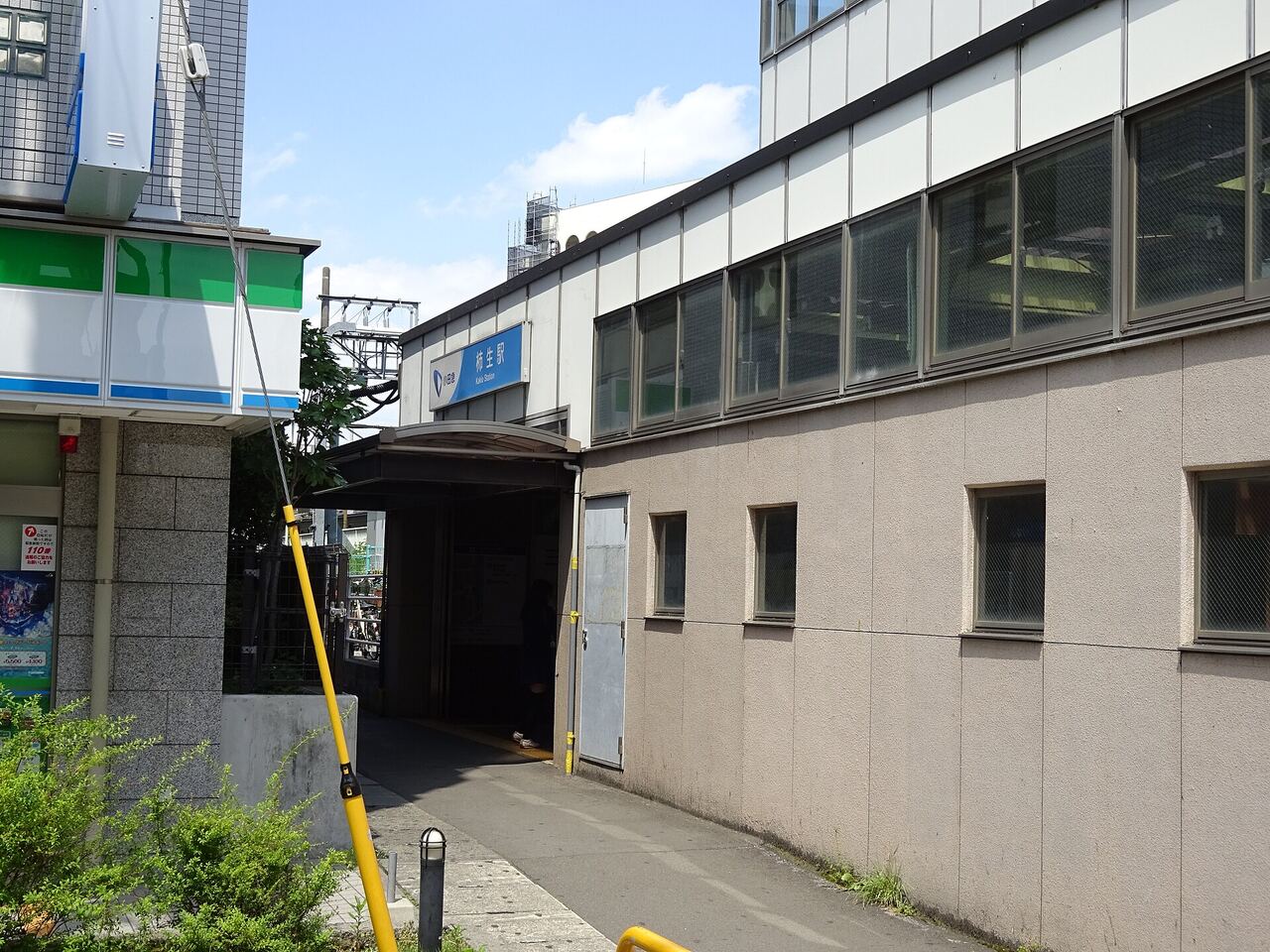 柿生駅の北口の入口。青い駅名の看板と、屋根のついた通路が見える