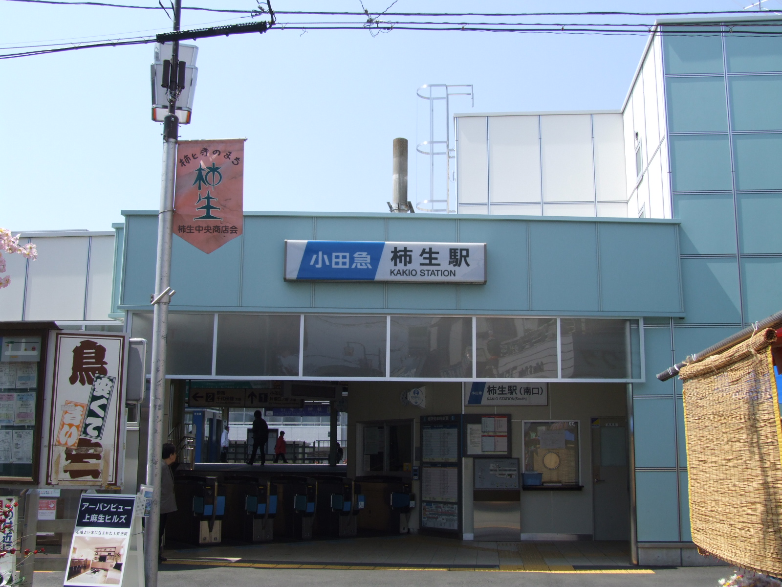 柿生駅の南口(2008年4月撮影)。駅名の看板の左に、「柿と寺のまち 柿生」と書かれた旗が下がっている