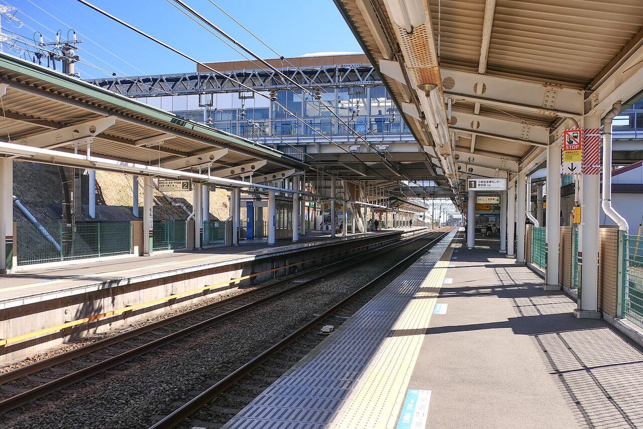 栗平駅のホーム。左右にホームがあり、上に通路の橋がかかっている。右のホームの案内には、小田急多摩センター、唐木田方面と書かれている