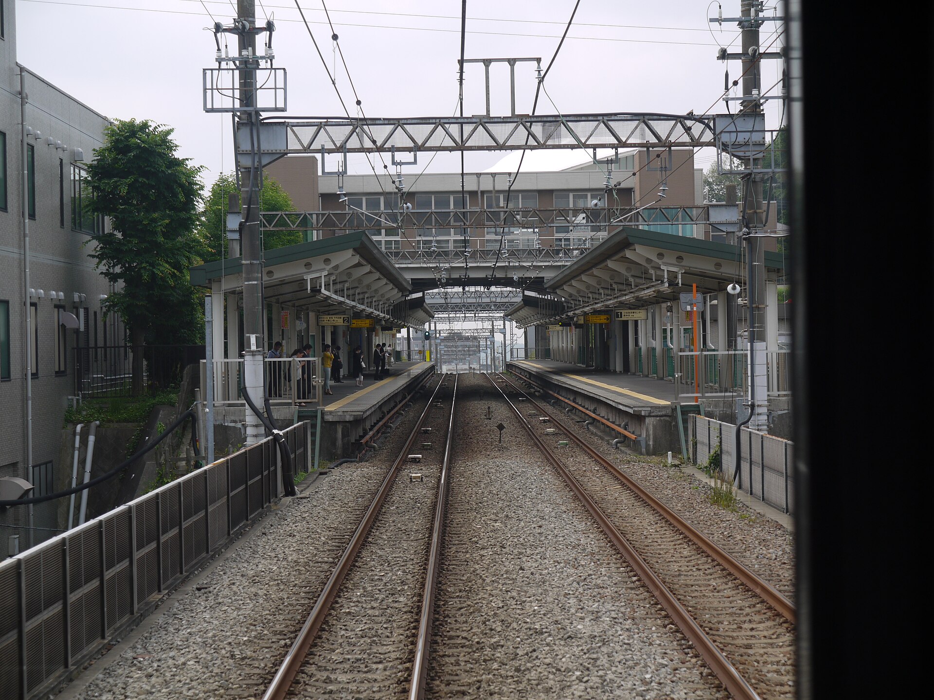 電車の先頭から見た黒川駅。屋根のあるホームが左右にあり、奥に駅の建物が見える