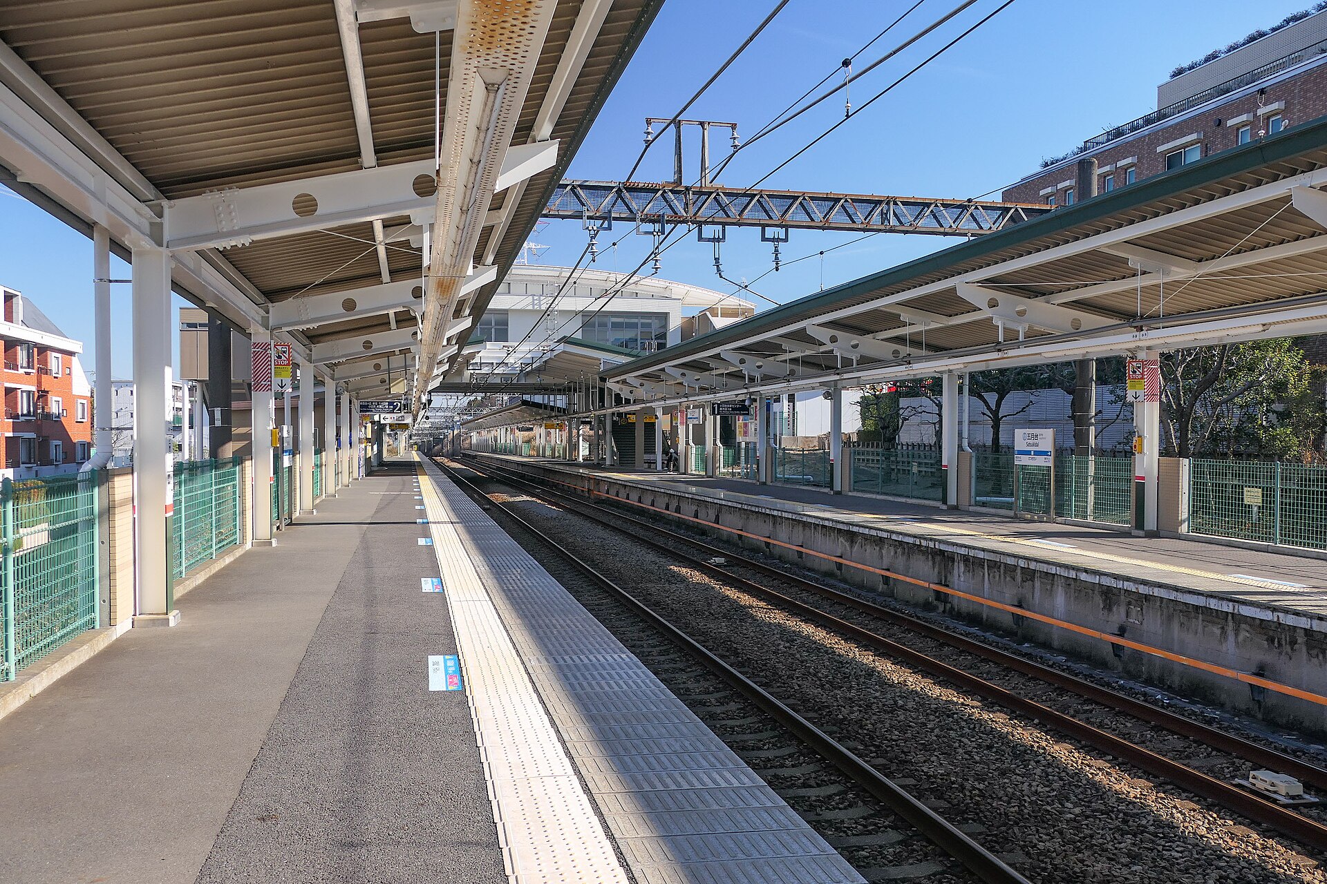 五月台駅のホーム。屋根のあるホームが2本並び、線路の向こうに、駅の建物の白い屋根が見える