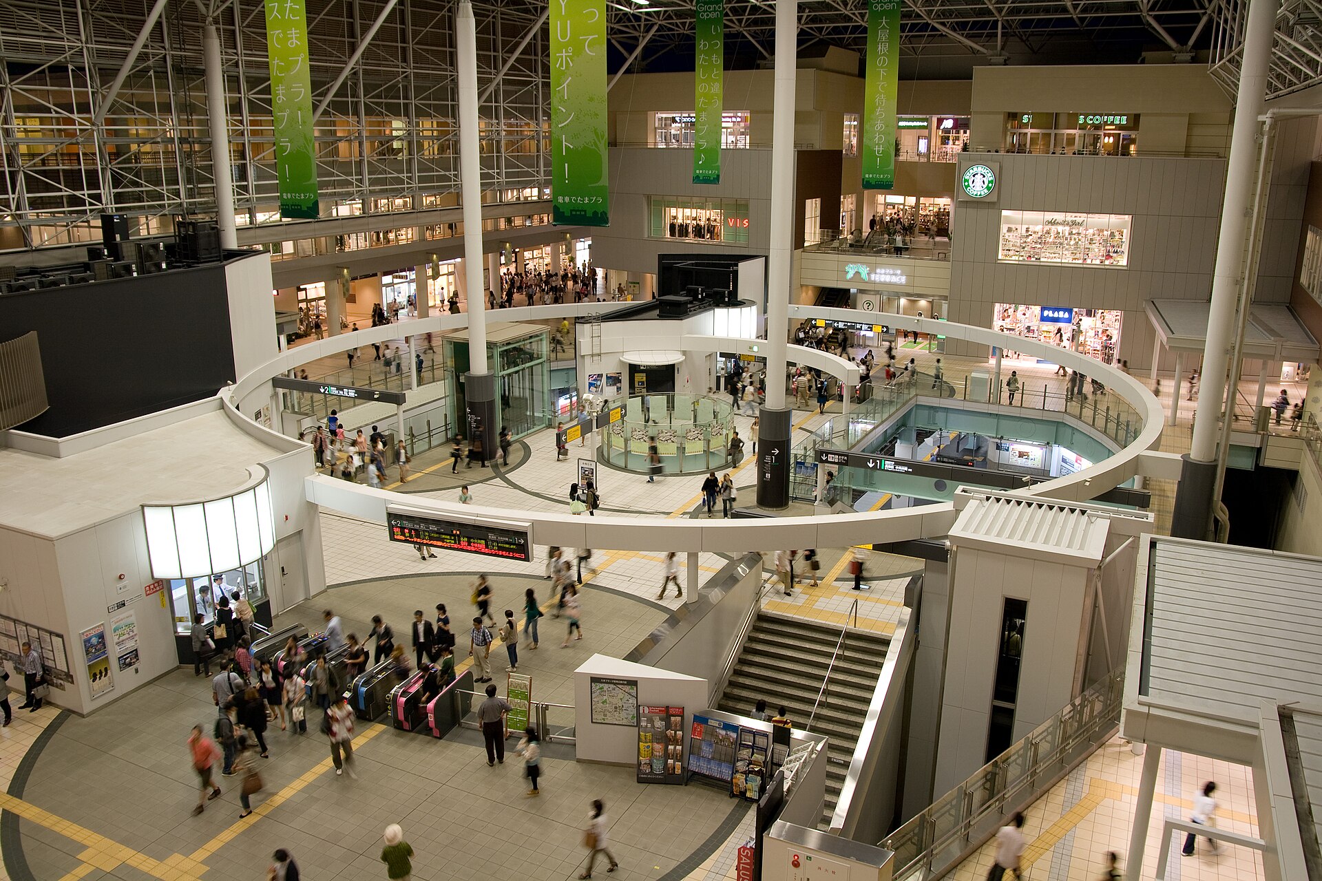 たまプラーザ駅の駅ビルの吹き抜け。改札の前に人が行き交い、上の階に店が並んでいる