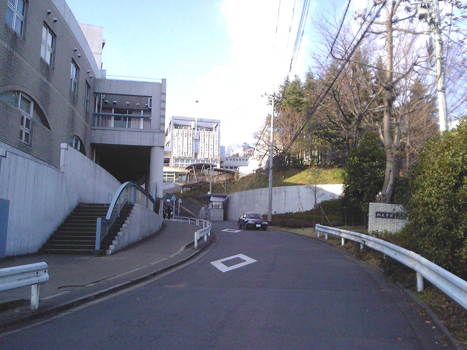 桐光学園の近くの坂道。左に校舎、奥にも建物が見える
